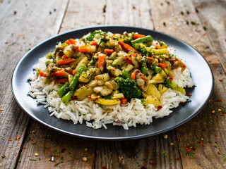 Roast meat, white rice and vegetables on wooden table
