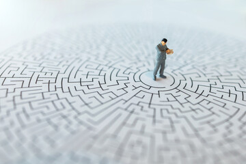 Miniature people : The man reading the book and standing on center of maze : Concepts of finding a...