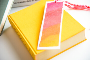 bookmark and a yellow book.
colourful bookmark on a closed yellow book. education. reading.