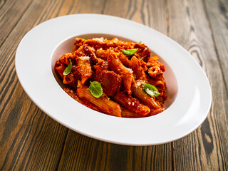 Penne with meat, tomato sauce and vegetables on white background
