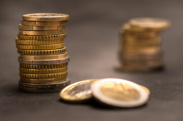 Euro stacked coins on black background whit cutting light