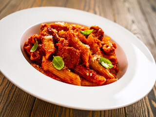 Penne with meat, tomato sauce and vegetables on white background
