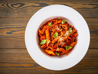 Penne with meat, tomato sauce and vegetables on white background
