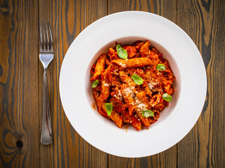 Penne with meat, tomato sauce and vegetables on white background
