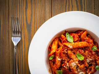 Penne with meat, tomato sauce and vegetables on white background
