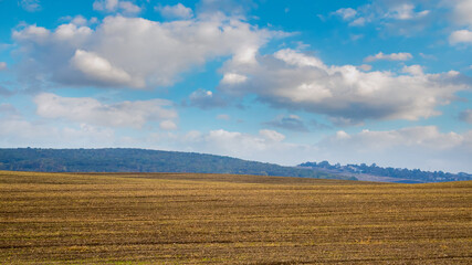 Obraz premium Field after harvest in autumn. Picturesque clouds over the autumn field