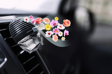 Air freshener clip attached to car ventilation. Flowered aroma