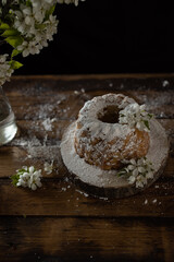 Rustic style apple bundt cake with powdered sugar on old wooden table