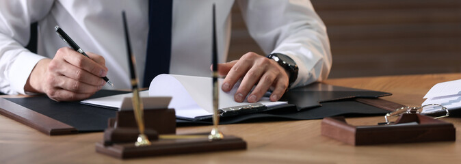 Male notary working at table in office, closeup. Banner design