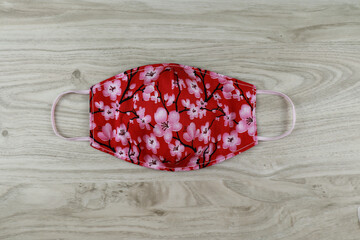Handmade project DIY face mask made out of red cotton fabirc. A washable fabric mask as mouth cover for extra protection.
