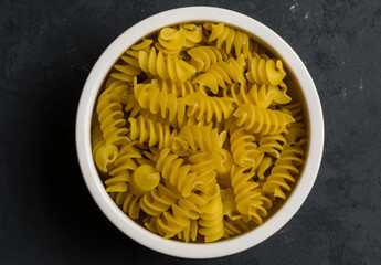 Macaroni in a white bowl against a dark background