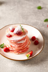 Stack of pink pancakes with strawberry. Pink colourful pancakes with berries. Breakfast