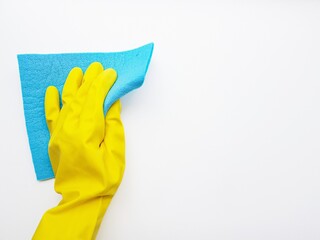 Cleaning the blue liquid with a blue sponge in a yellow rubber glove on a white background. Space for text.