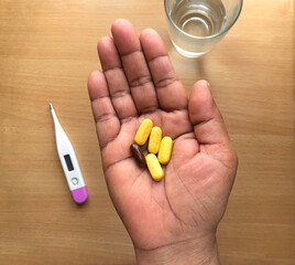 Medicine pills or capsules in hand.