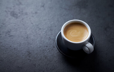 Cup of coffee on dark stone background. Close up. Copy space
