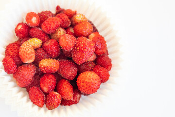 Wild strawberry served in decorative paper basket isolated on white background.