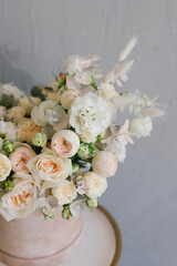 Beautiful bouquet of flowers in a box. A bouquet in peach tones. Stylish bouquet of peonies, ranunculis and roses. Flower shop concept. Floristics