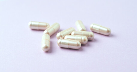 Carnitine capsules. Concept for a healthy dietary supplementation. Bright paper background. Soft focus. Close up.