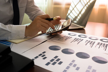 Businessman or Accountant in white suit and tie using a calculator to calculate balance, finances,...
