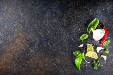 Assortment of spices, herbs and greens. Ingredients for cooking. Food background. Black stone...