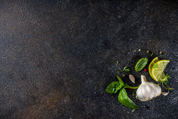 Assortment of spices, herbs and greens. Ingredients for cooking. Food background. Black stone table, Copy space for text. Top view.