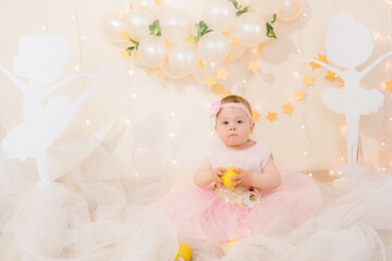 Cute little girl in a pink princess dress with a flower on her hair plays with wooden ballerinas...