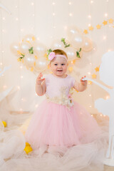 Cute little girl in a pink princess dress with a flower on her hair plays with wooden ballerinas...