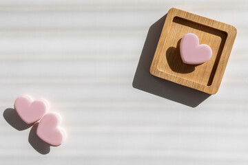 Pink heart-shaped plastic box on a little wooden stand