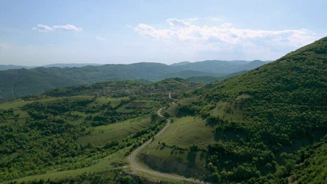 Aerial video flying over green meadows, forests and hills overgrown with lush vegetation in the spring time. The picturesque valley between hills of Eastern Balkan Mountains.