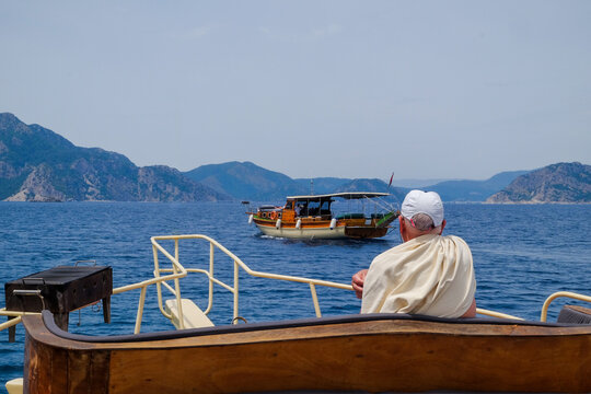 an aged senior man on a luxurious yacht boat looking at the blue sea. ocean vacation transport. marine boat trip. rich seniors travel after retirement. Marmaris Turkey Mugla Aegan sea 