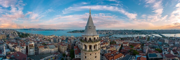 Panoramic view of Galata Tower and Istanbul Bosphorus with a cloudy sky.