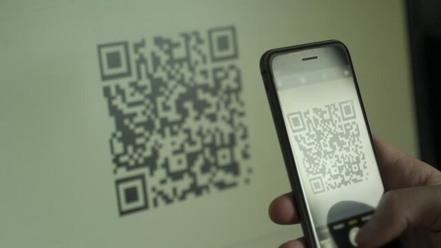 Hand holding smartphone, scanning qr code with smartphone - Powered by Adobe