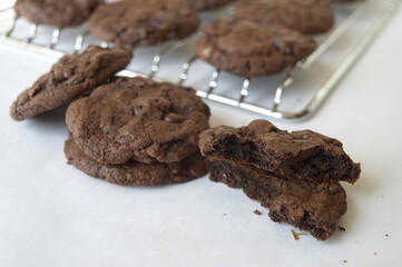 Closeup homemade round chocolate cookies on cake cooler with blurred background in kitchen