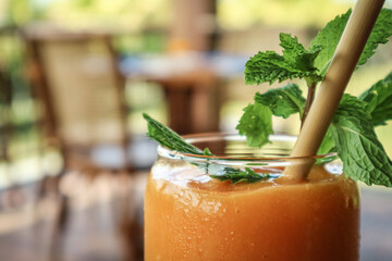 Mango smoothie in glass with bamboo drinking straws