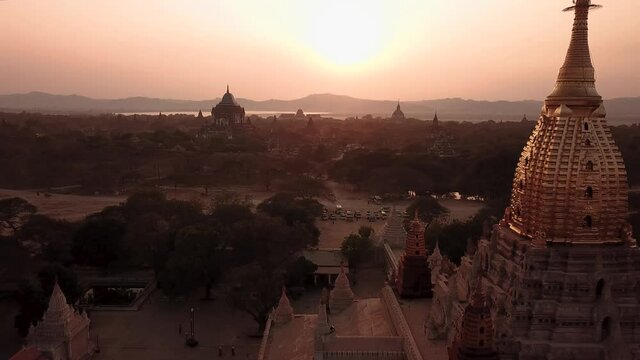Ananda Buddhist Temple. Bagan City, Myanmar, Pull Back Drone Aerial View of Scenic Landscape Under Golden Hour Sunlight Backlight