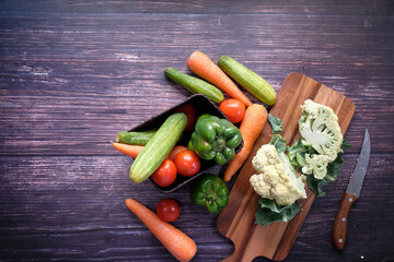 Healthy food selection with fresh vegetables on chopping board on table 