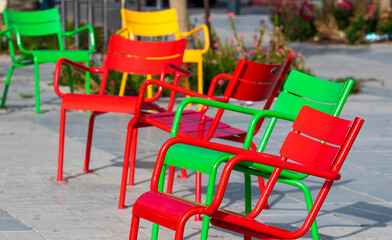 metal chairs red, green and yellow in the city park