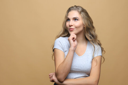 Image of happy young woman standing isolated over beige wall background.
