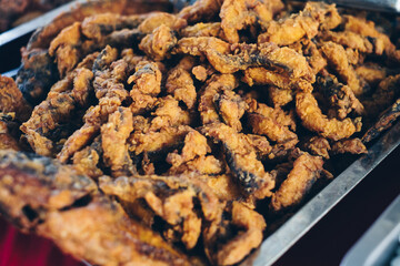Close up of crispy fillet Chicharon Tilapia in stainless steel catering dish. Selective focus.