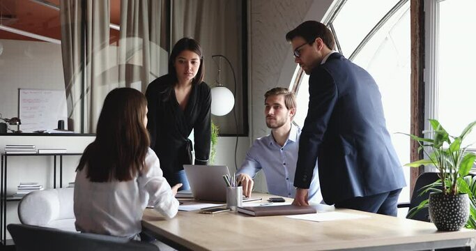Diverse professional work team brainstorming in modern office. Young people company staff workers business group engaged in teamwork discussion working together sharing ideas during corporate meeting.