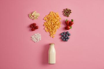 Delicious nourishing breakfast. Bottle of milk or yoghurt with granola and tasty ingredients to add. Dried apple, raspberry, coconut flakes, pistachio, strawberry, blueberry for preparing tasty meal