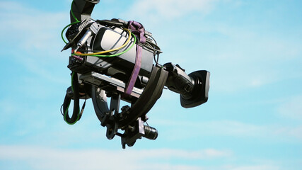 Professional TV broadcast camcorder on a camera crane arm - sky background