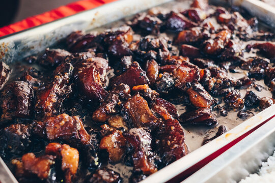 Close up of delicious and tender Filipino Pork Humba with salted black beans, a Visayan version of pork adobo or braised pork, in stainless steel catering dish. Selective focus.