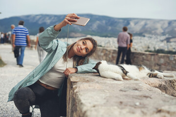 Athens, Greece. Young woman taking selfie with a cat on the street of Athens, Greece