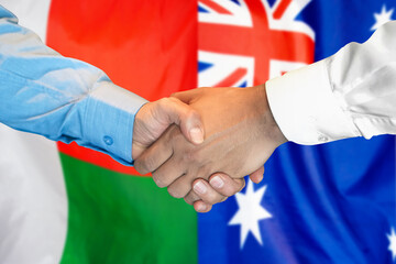 Handshake on Madagascar and Australia flag background. Support concept.