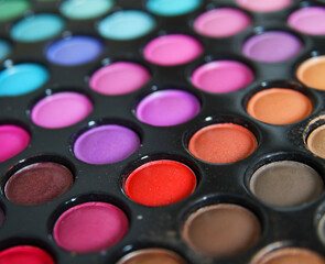 Professional multicolor eyeshadow make up palette background, close-up. Colorful bright eye shadows set backdrop