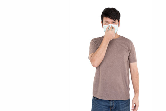 Asian Man Wearing Surgical Protection Face Mask And Touching The Mask At The Nose By One Hand, Studio Light Isolated On White Background, Concept For Coronavirus, COVID19