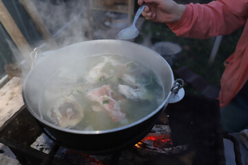 cooking fish soup on the grill in a pot for the family in the fresh air, cooking on the grill, proper nutrition in the campaign