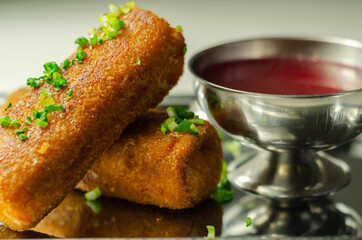 Delicious croquettes with sauerkraut and mushrooms served with hot red borscht on the silver tray