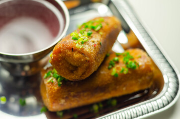 Delicious croquettes with sauerkraut and mushrooms served with hot red borscht on the silver tray
